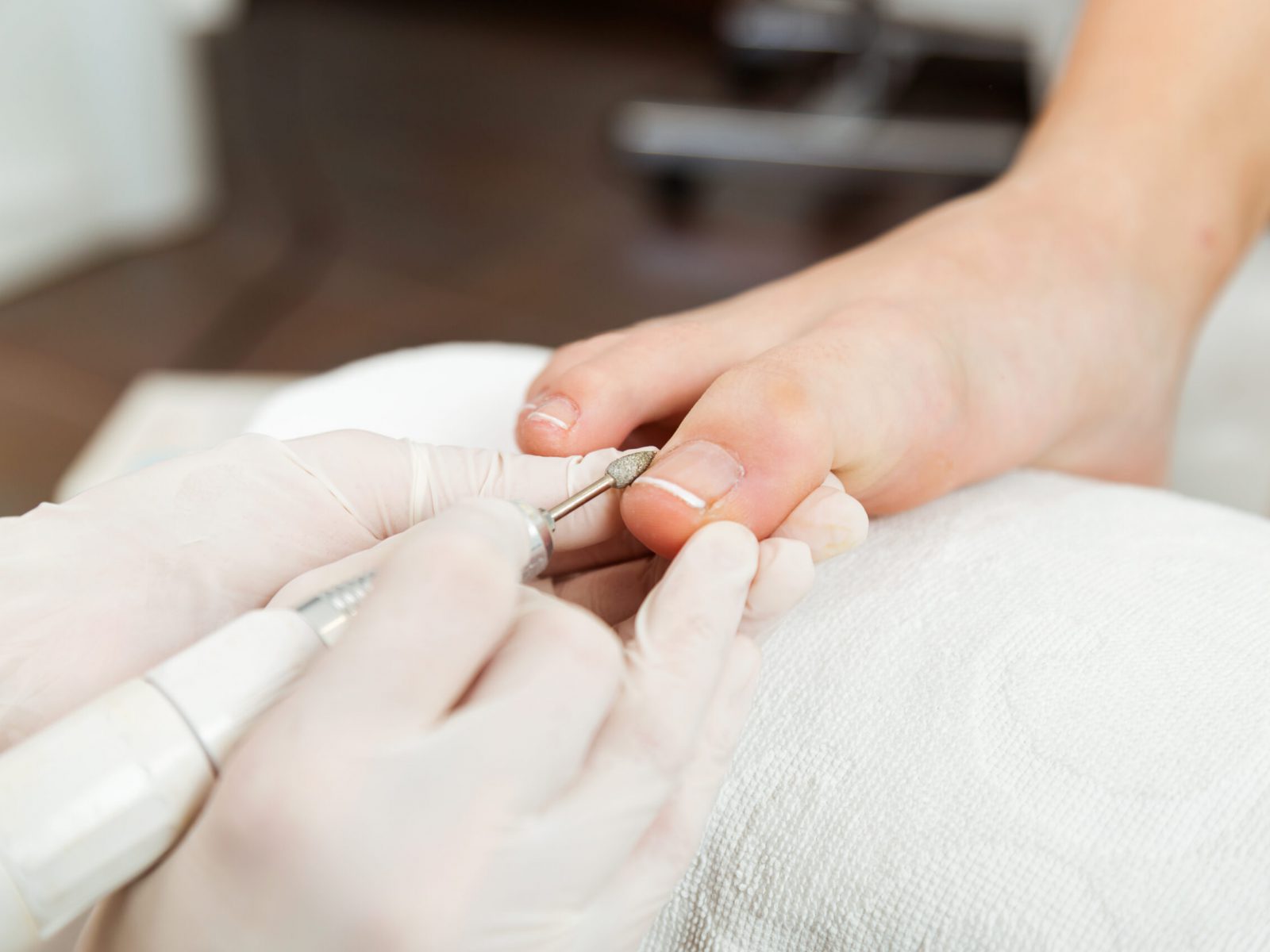 Portrait of young woman doing pedicure in salon. Beauty concept.